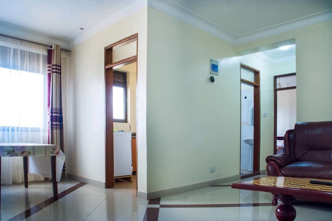 Una sala de estar con un sofá, una mesa y una puerta que da a otra habitación.