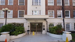 A building entrance with a sign reading "No 1 to 51" and a fire safety notice. - Park West by Allô Housing (London)