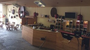 A bar area with wooden furniture, wine racks, and hanging lights. - Domaine Sylvie Fahrer & Fils (Saint-Hippolyte)