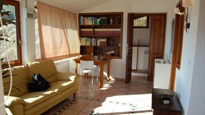 Un salon confortable avec un canapé, une table à manger et une bibliothèque.