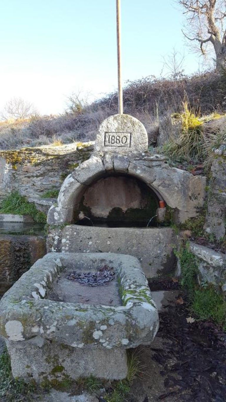 Edifici de pedra antic amb una obertura circular i una placa amb la inscripció '1880'.