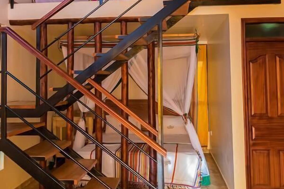A multi-level wooden staircase with metal railings and a canopy.