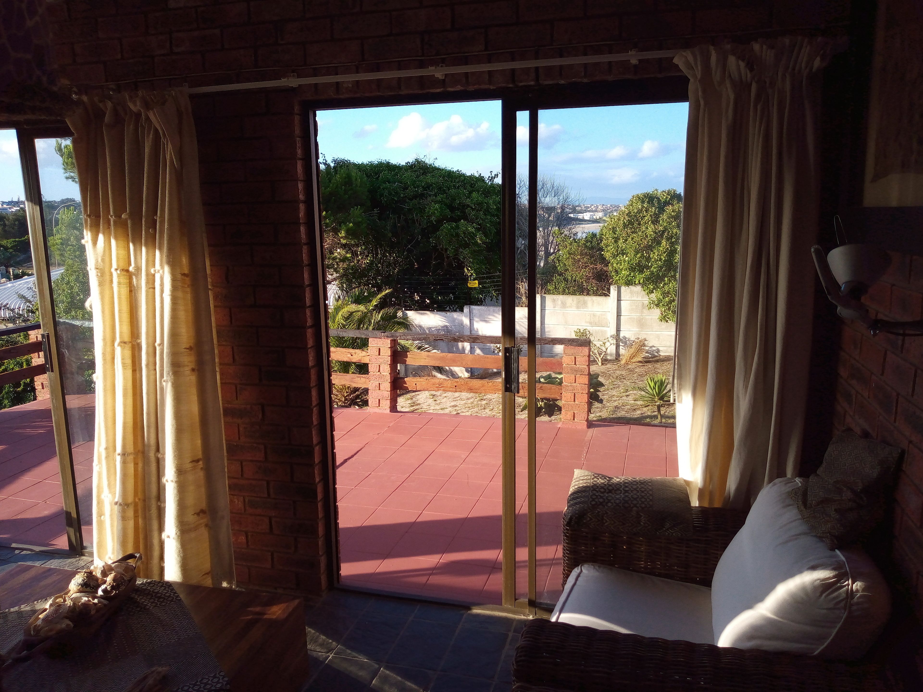 A room with a view of a garden and a brick wall.
