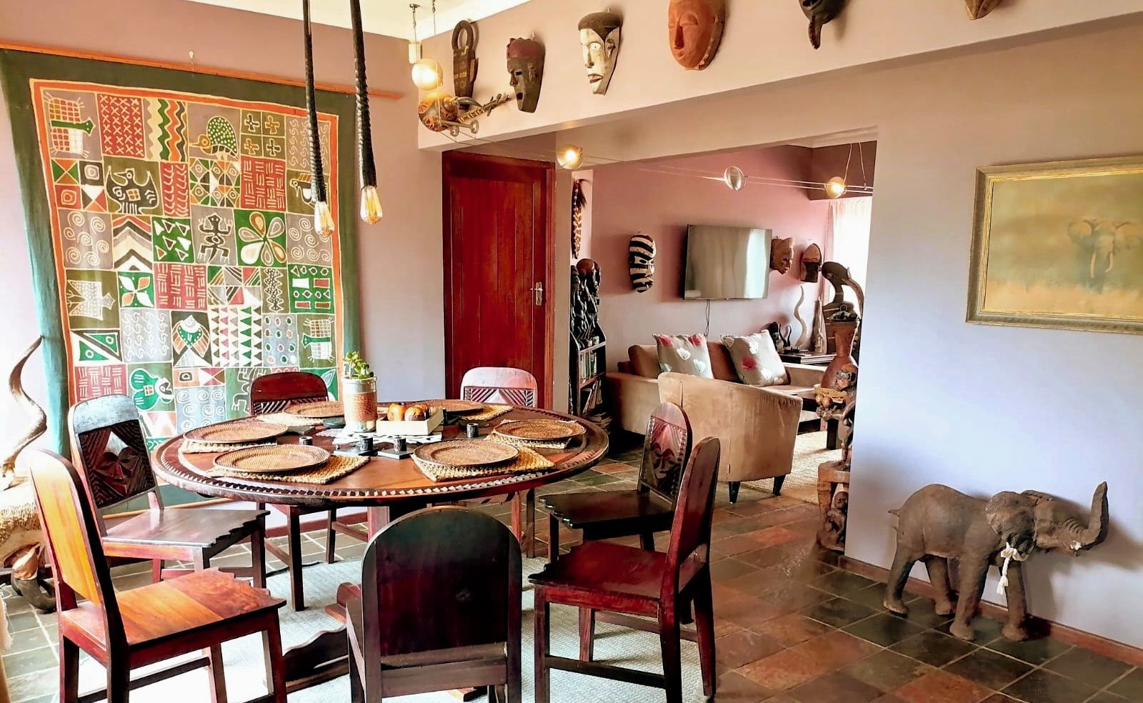 A dining area with a round table, chairs, and a patterned wall.