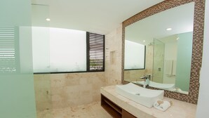 A modern bathroom with a large mirror, a white sink, and a shower area. - Anah Downtown DT 201B (Playa del Carmen)