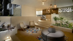 Een modern interieur met een zithoek, een trap en een muur waarop het woord 'ANAHIL' verlicht is.