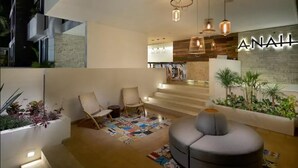 Un intérieur moderne comprenant un espace salon, un escalier et un mur orné d’une enseigne « ANAHL ».