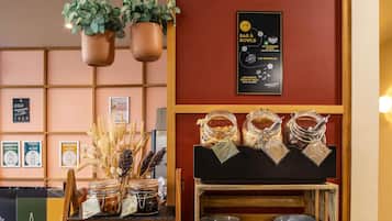 Un espace buffet proposant une variété de plats, notamment des bocaux de granola et des noix, ainsi qu’un assortiment de bols et d’assiettes.