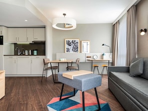 A modern apartment with a kitchen, dining area, and living room. - Aparthotel Adagio Paris Nation (Paris)
