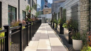 A narrow urban pathway flanked by buildings with large windows and potted plants. - Element by Marriott Minneapolis Downtown (Minneapolis)
