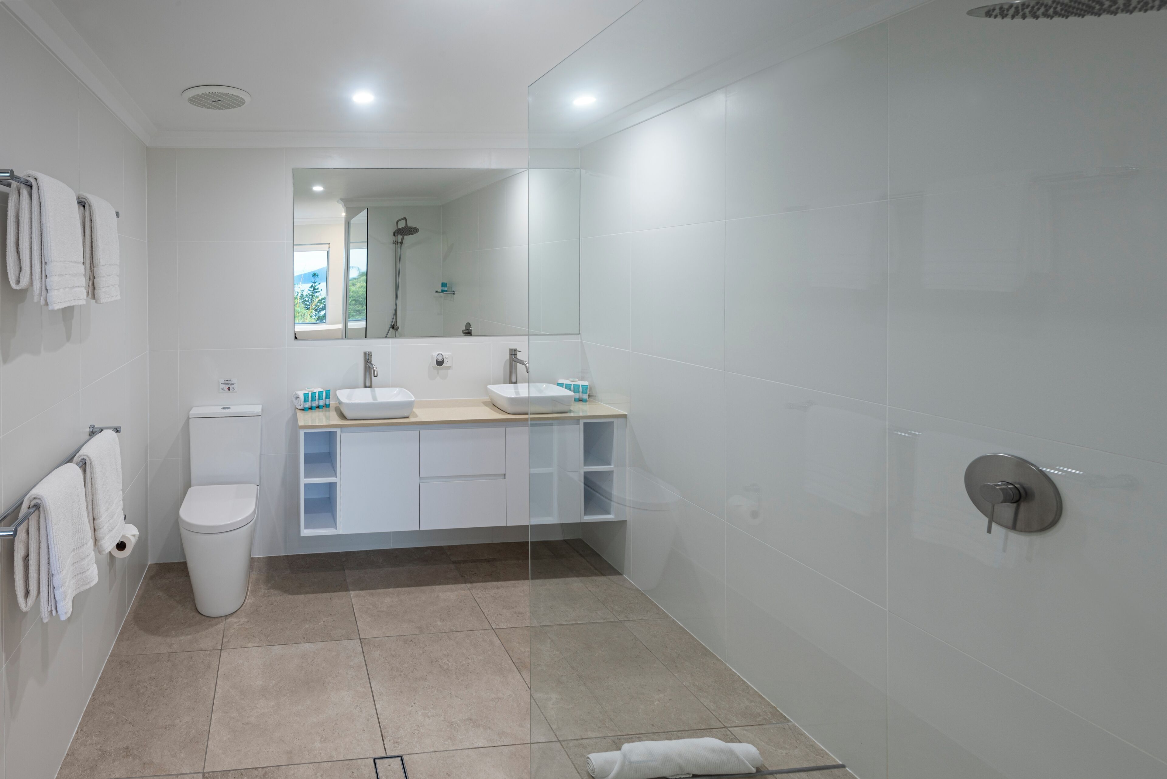 A modern bathroom with a toilet, sink, and shower.