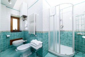 Tina con regadera, secadora de cabello, bidet, toallas 