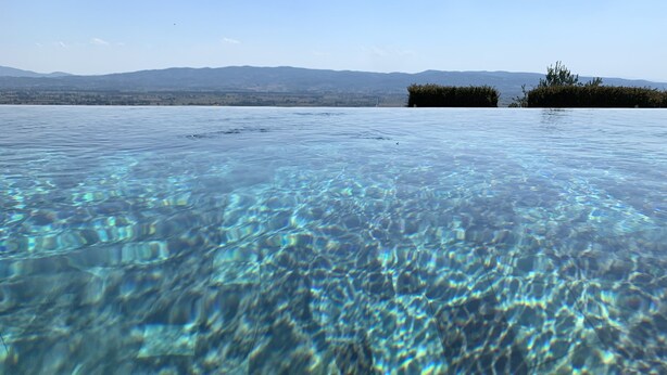 A clear view of a swimming pool with a distant landscape.