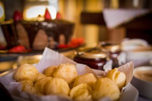Una bandeja de pasteles y un postre de chocolate al fondo.