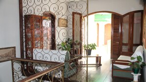 A room with a wooden staircase, a green plant, and a wooden cabinet with glass doors. - Hotel Chalé São Jorge (Aparecida)