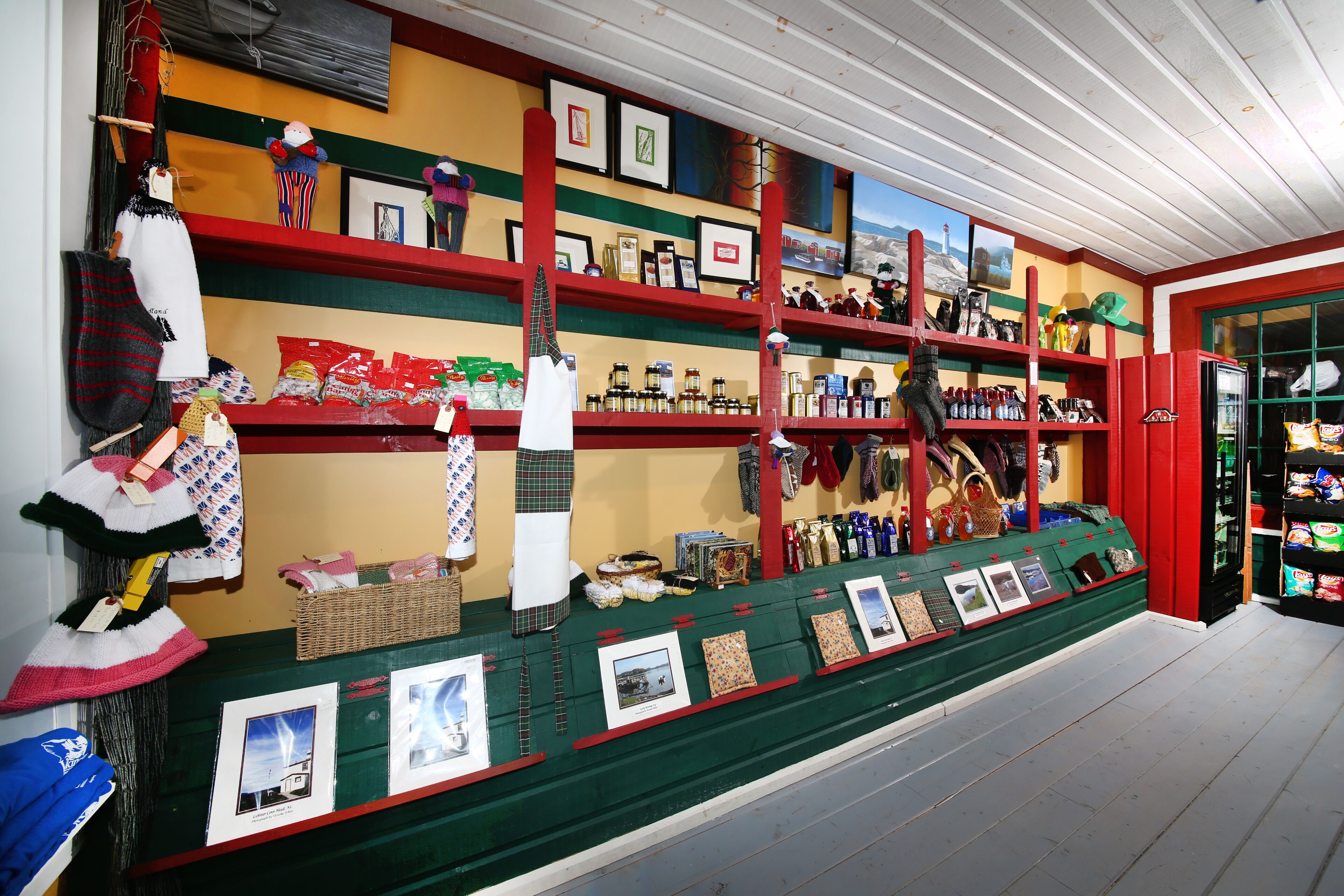 Un magasin où l’on trouve, sur des étagères, une variété d’articles, notamment des chapeaux, des sacs et des tableaux encadrés.