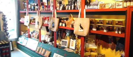 A store with shelves stocked with various items including bags, books, and other merchandise.