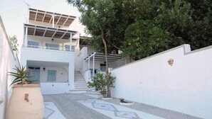 Un edificio moderno de dos pisos con una escalera cubierta y un patio empedrado.