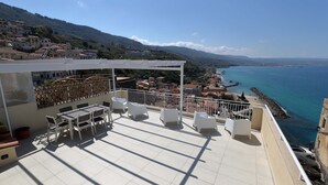A rooftop terrace with outdoor furniture, a pergola, and a view of the sea and town below. - b & b in the historic center, with a panoramic terrace, 400 meters from the sea (Pizzo)