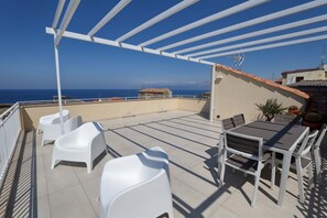 A rooftop terrace with a table and chairs, a pergola, and a view of the sea. - b & b in the historic center, with a panoramic terrace, 400 meters from the sea (Pizzo)