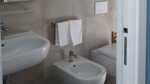 A modern bathroom with two sinks, a bidet, and a towel rack. - b & b in the historic center, with a panoramic terrace, 400 meters from the sea (Pizzo)