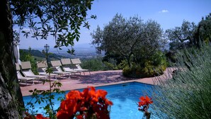 Un espace piscine avec des chaises longues et une vue sur le paysage.