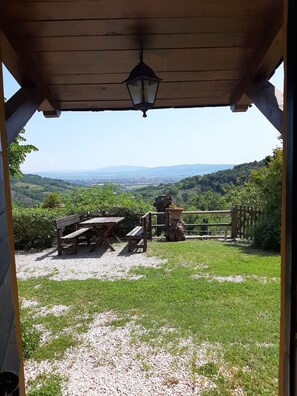 A wooden pergola with a lantern, overlooking a grassy area with a wooden bench and a rustic gate. - Locanda dell' Angelo (Assisi)