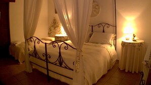 Un lit à baldaquin avec des rideaux blancs, une horloge ronde fixée au mur et deux lampes de chevet.