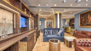 A modern living room with a blue sofa, a brown leather sofa, and a coffee table.