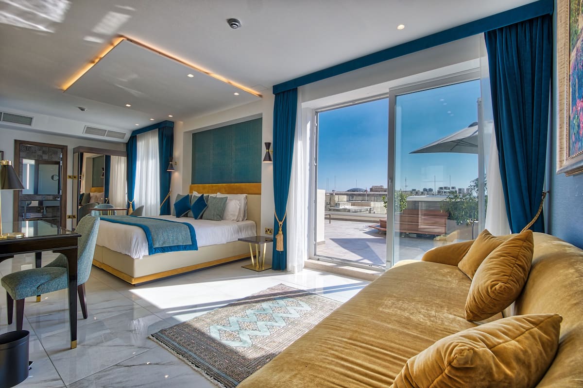 Ein modernes Hotelzimmer mit einem großen Bett, einem Schreibtisch und Blick auf die Stadt.