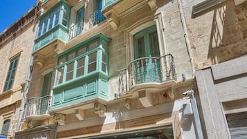 A historic building with multiple balconies, a shop window labeled "YUM," and a sign for "PALAZZO ROSARIA."