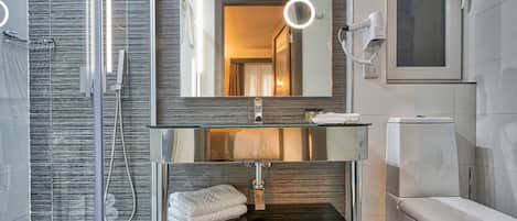 A modern bathroom with a glass shower enclosure, a vanity with a mirror, and a toilet.
