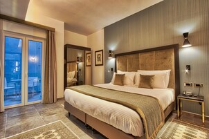 Un'ampia camera da letto con un letto grande, una porta vetrata scorrevole su un balcone e un comodino con una lampada.