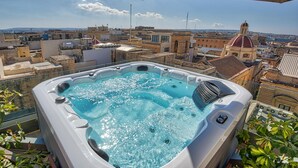 A hot tub on a rooftop with a city view.