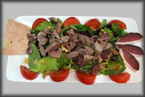 A rectangular white plate with a salad containing lettuce, cherry tomatoes, and pieces of meat. - Camping Le Verdoyant - Chalets (Thenon)