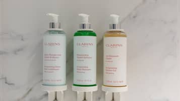 Three Clarins Paris skincare products on a marble surface.