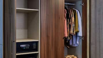 Un dressing accessible sans porte, avec des panneaux en bois, un appareil électroménager intégré et des vêtements suspendus.