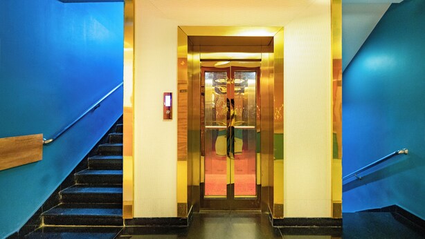 A hotel lobby with a blue staircase leading to an elevator. - Hotel SDM Golden Tower (Rameshwaram)