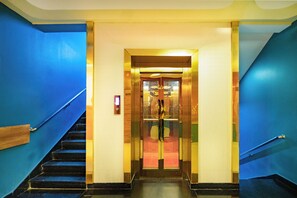 A hotel lobby with a blue staircase leading to an elevator. - Hotel SDM Golden Tower (Rameshwaram)