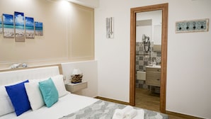 A hotel room with a bed, a nightstand, a lamp, a mirror, and a view into the bathroom. - B&B Dimora del Pescatore Cefalù (Cefalù)