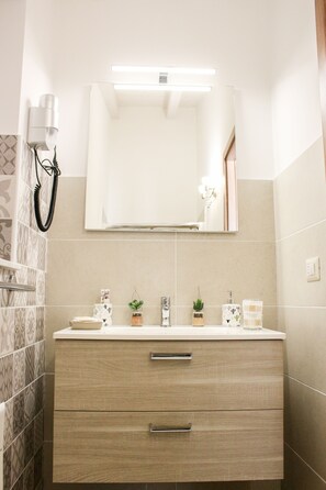 A bathroom with a mirror, a sink, and a vanity with drawers. - B&B Dimora del Pescatore Cefalù (Cefalù)