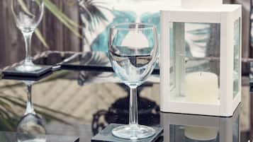 A table with two wine glasses, a candle in a lantern, and cutlery.