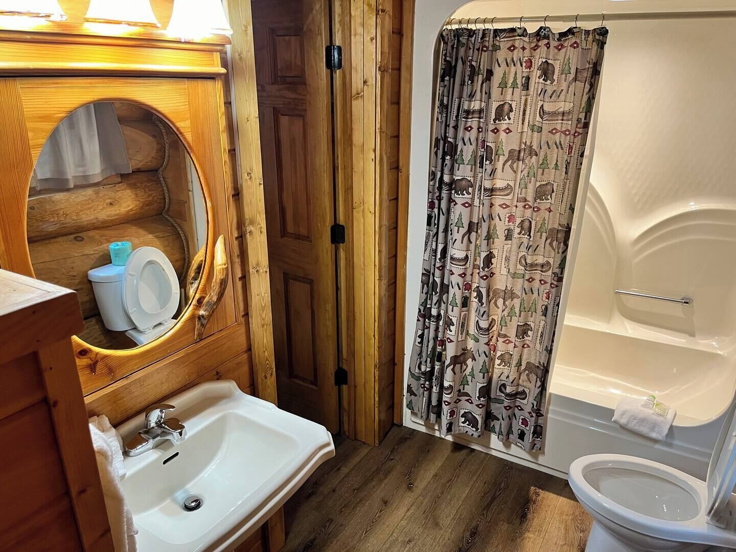 Et badeværelse i en træhytte med vask, toilet og badekar.