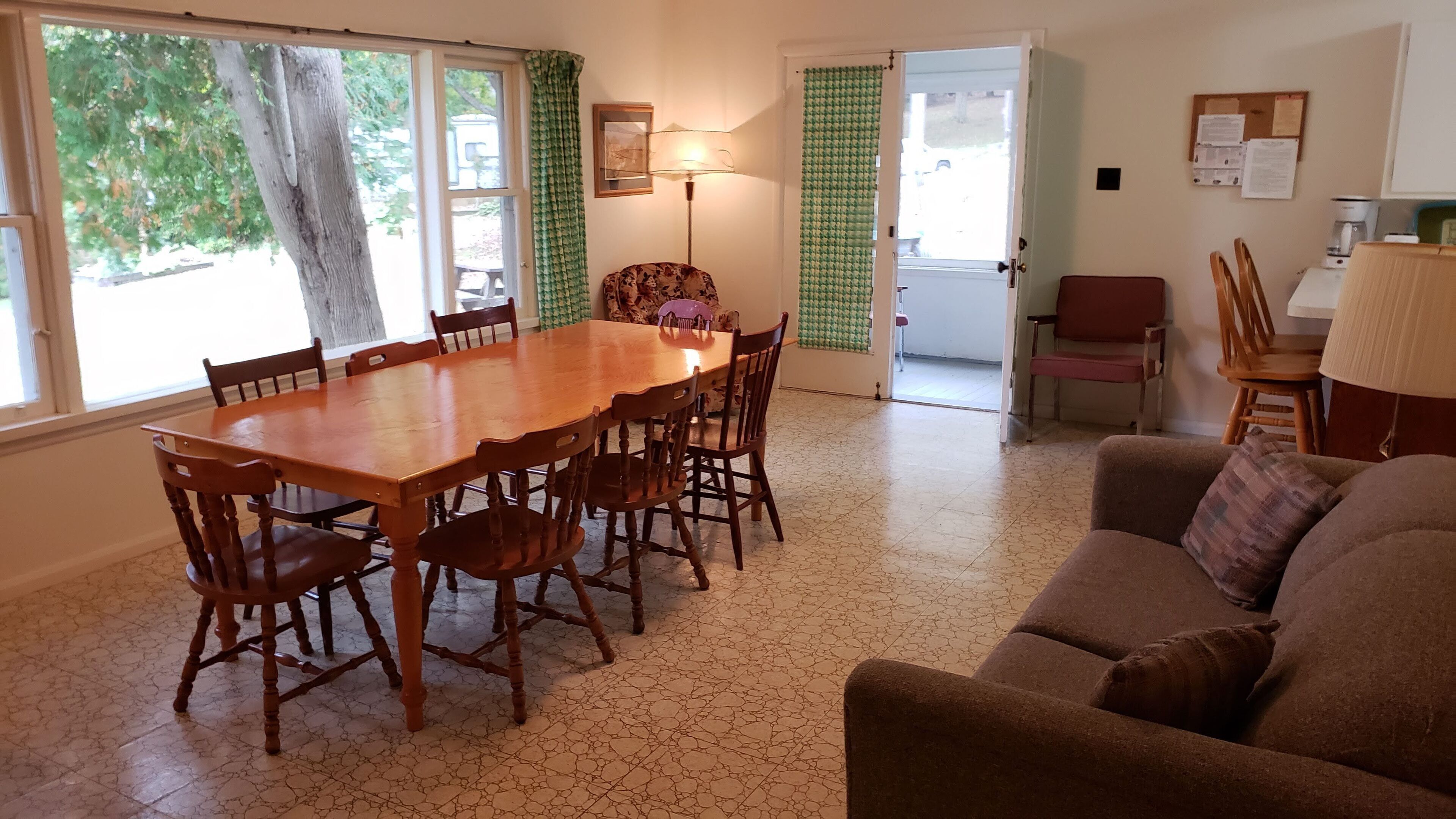 Un coin repas avec une table et des chaises en bois, un canapé et une lampe.
