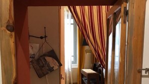 Una puerta de madera que da a una habitación con suelo de espiga, una silla y una mesa.