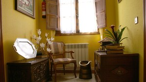 A room with a wooden cabinet, a chair, a radiator, and a window with curtains. - Casa Rural Priena (Cangas de Onis)