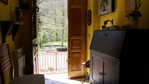 A room with a wooden door leading to a balcony, a cabinet, and a small table. - Casa Rural Priena (Cangas de Onis)