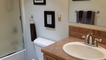 Eenvoudig appartement | Badkamer | Een bad/douchecombinatie, een hydromassagedouche, een haardroger