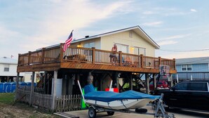 Ein Haus mit einer Holzterrasse und einem Boot auf einem Anhänger.