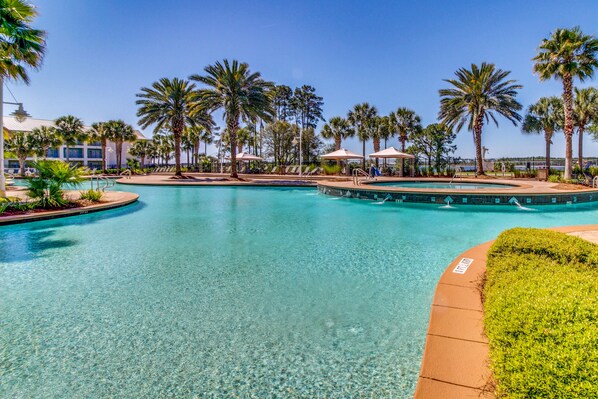 Relax by the serene pool surrounded by palm trees and sun loungers.